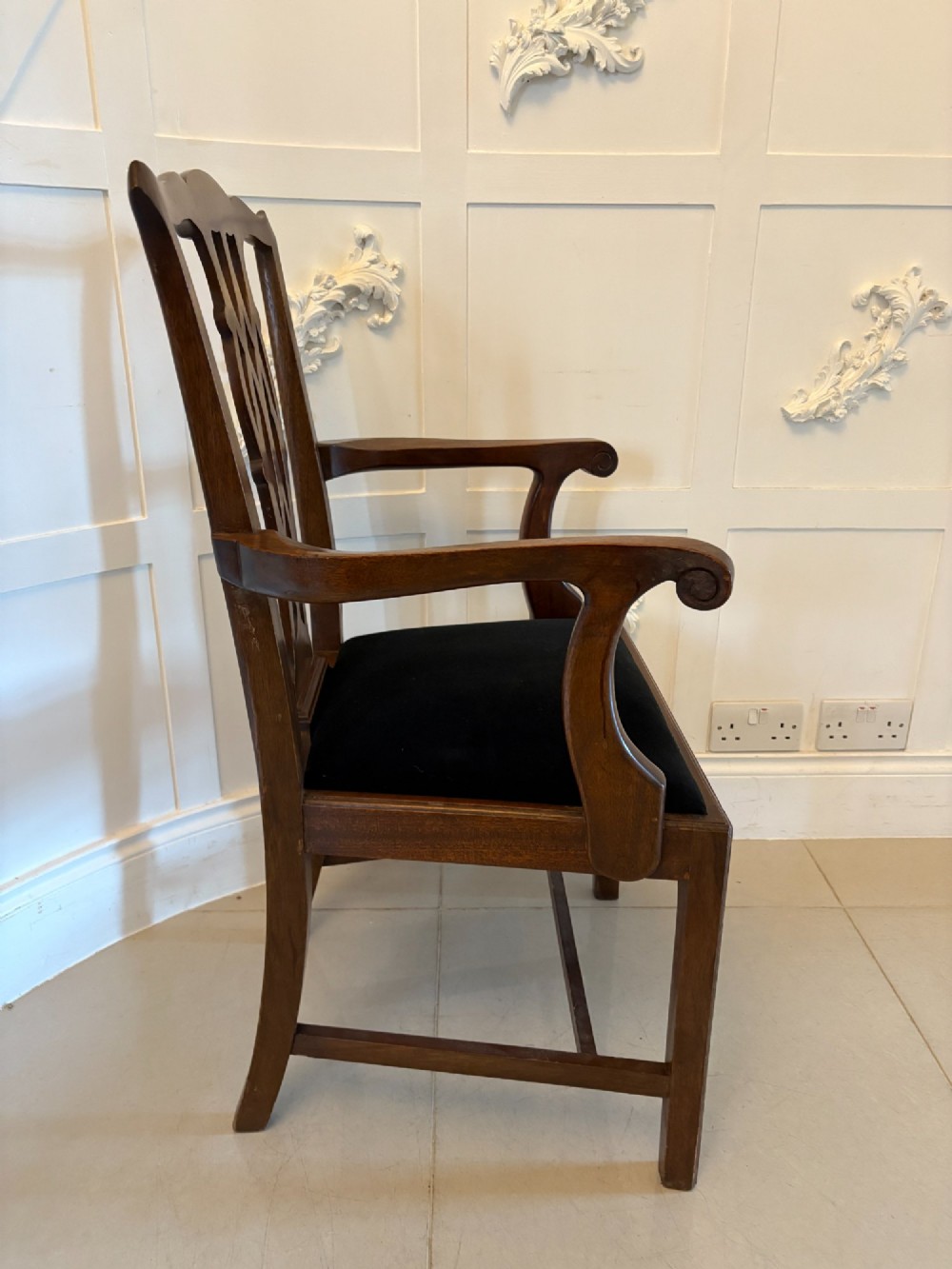 A set of eight Edwardian mahogany dining chairs featuring pierced fretwork splats and black velvet upholstered seats, comprising two carver armchairs and six side chairs. View IV