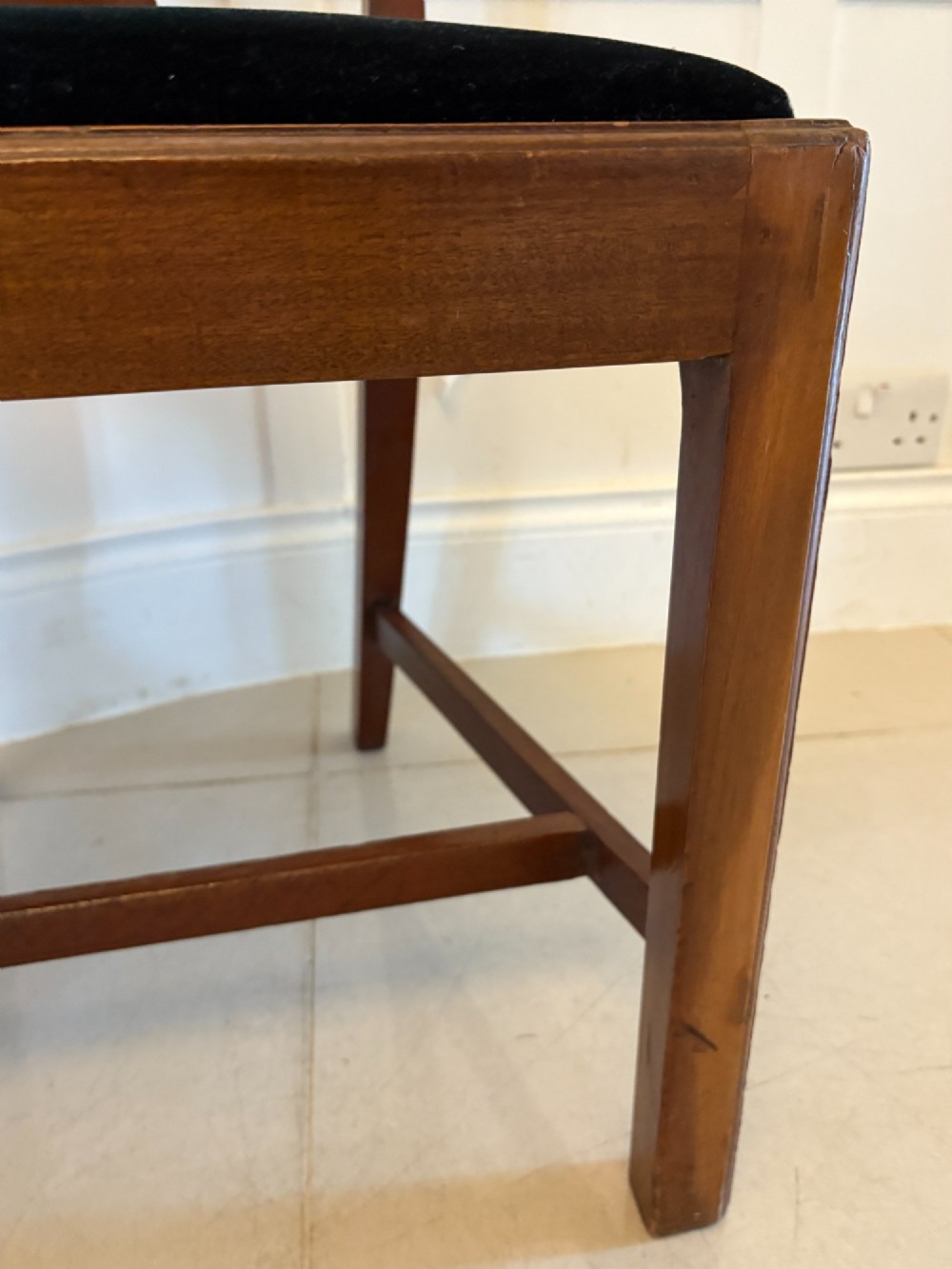 A set of eight Edwardian mahogany dining chairs featuring pierced fretwork splats and black velvet upholstered seats, comprising two carver armchairs and six side chairs. View VI