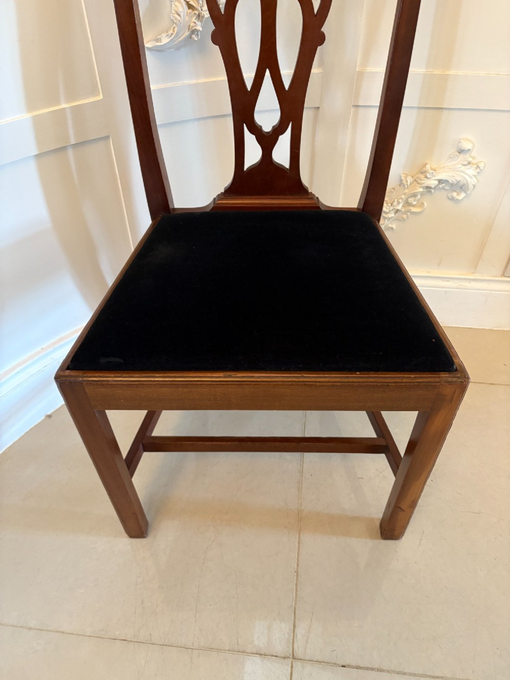 A set of eight Edwardian mahogany dining chairs featuring pierced fretwork splats and black velvet upholstered seats, comprising two carver armchairs and six side chairs. View VII