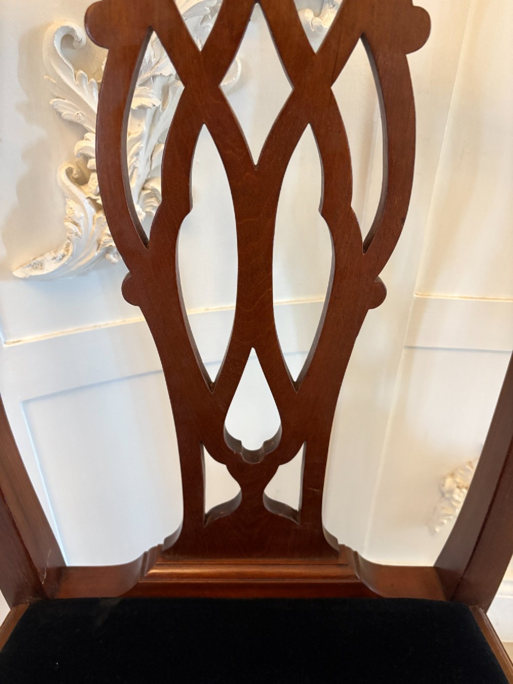 A set of eight Edwardian mahogany dining chairs featuring pierced fretwork splats and black velvet upholstered seats, comprising two carver armchairs and six side chairs. View VIII