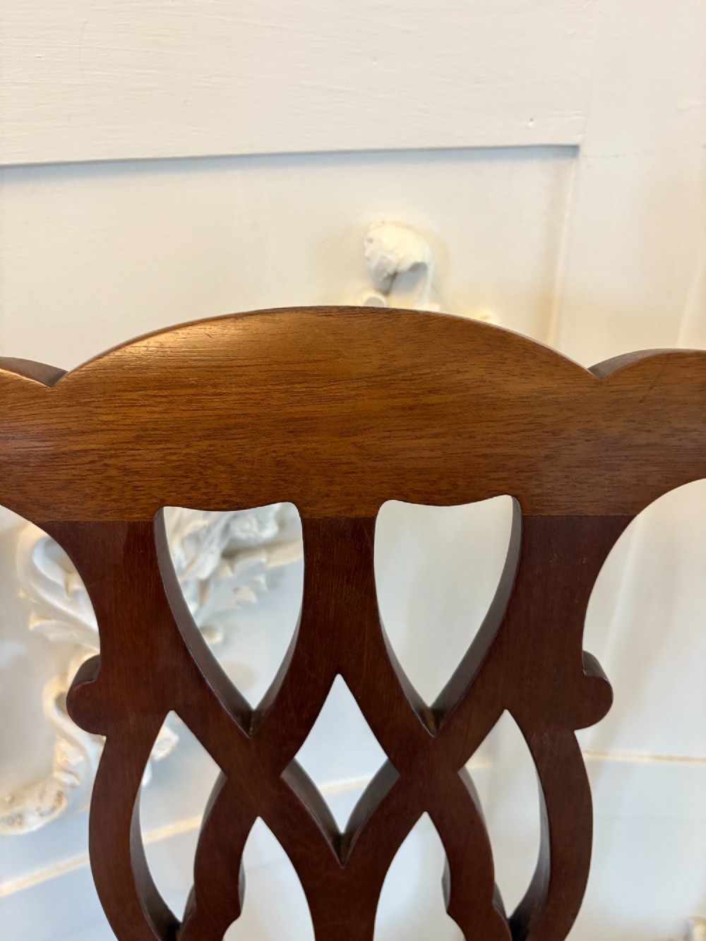 A set of eight Edwardian mahogany dining chairs featuring pierced fretwork splats and black velvet upholstered seats, comprising two carver armchairs and six side chairs. View IX