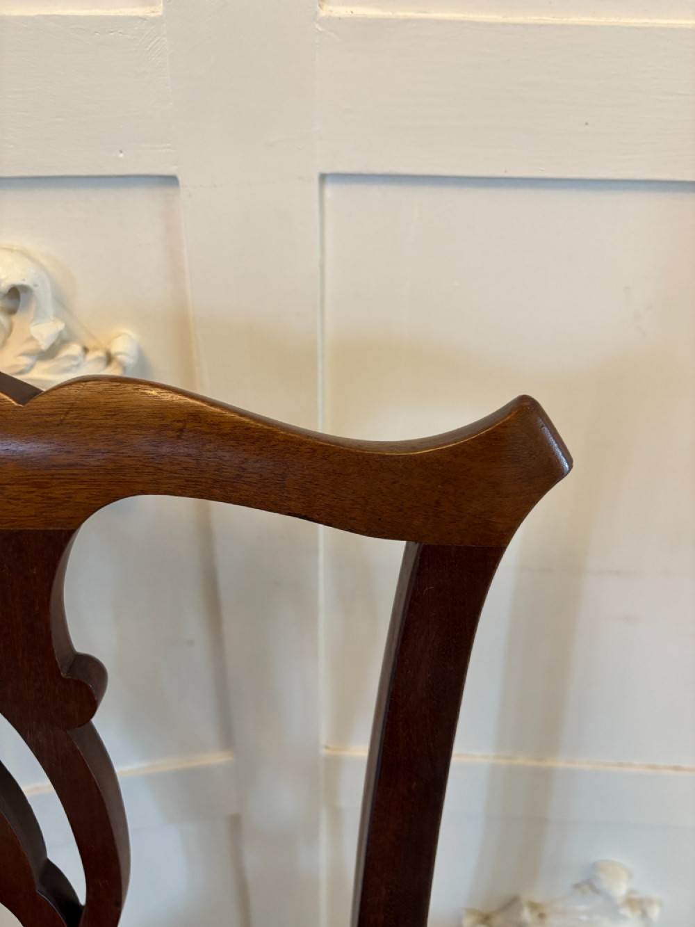 A set of eight Edwardian mahogany dining chairs featuring pierced fretwork splats and black velvet upholstered seats, comprising two carver armchairs and six side chairs. View X