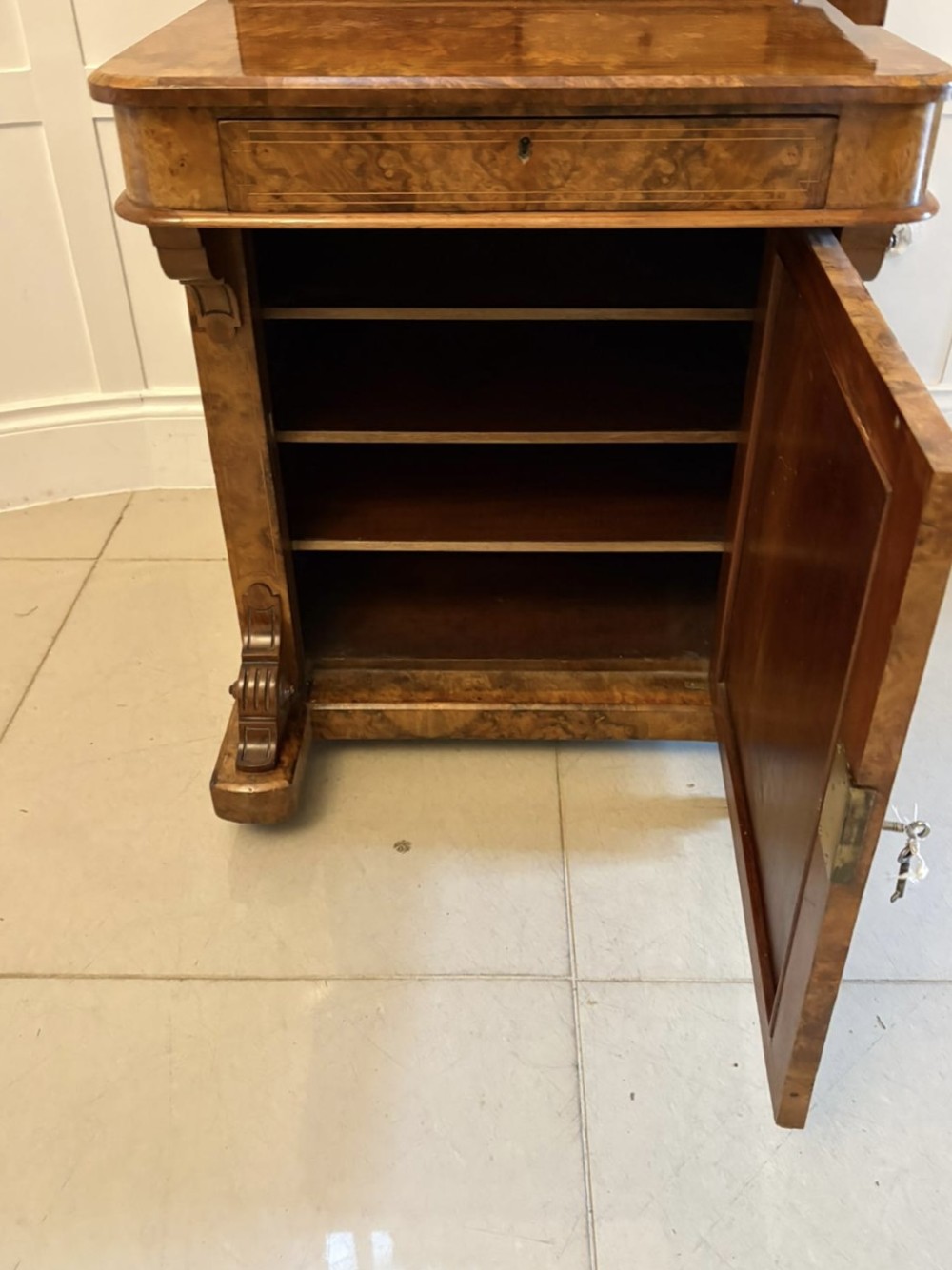 A Victorian burr walnut Davenport desk with floral marquetry inlay, a brass top gallery, and carved scroll feet. View VI