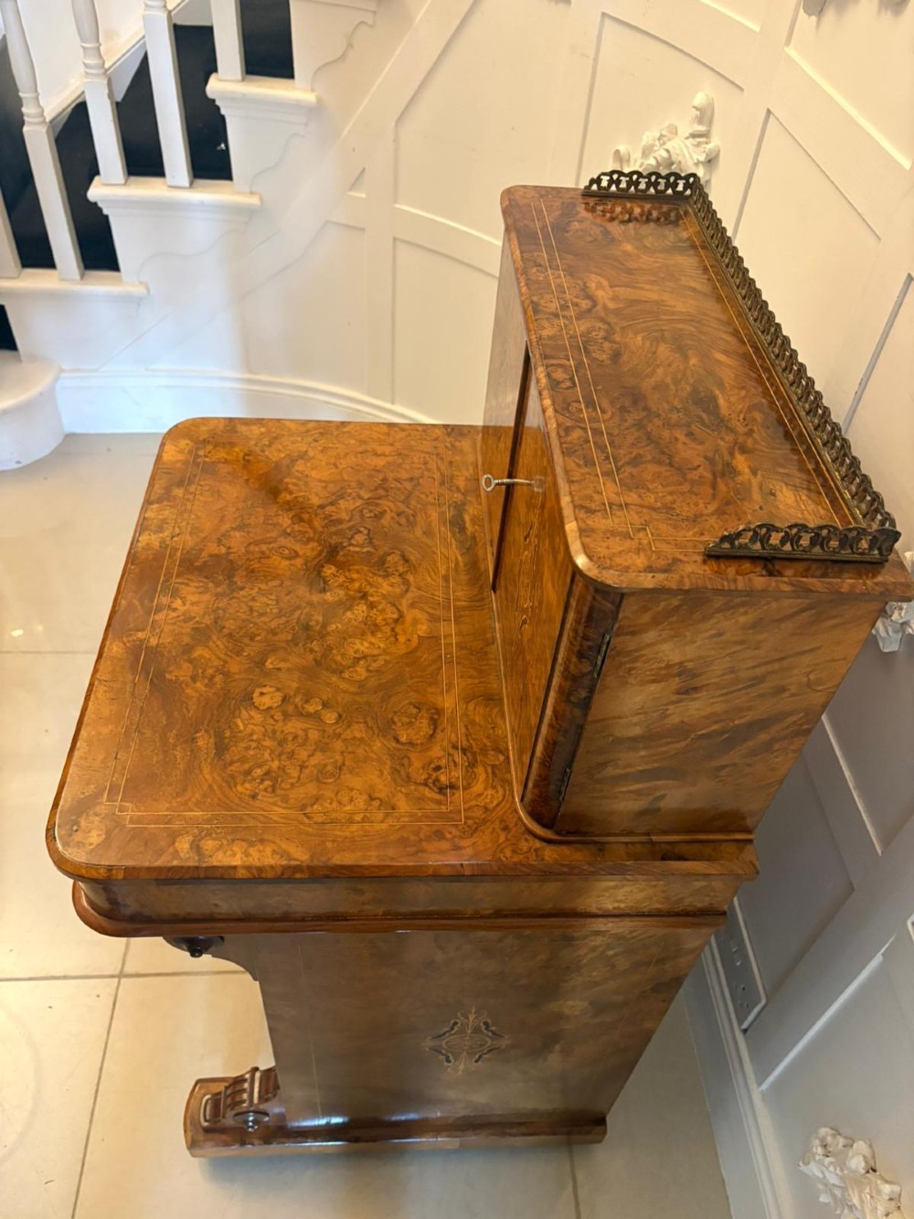 A Victorian burr walnut Davenport desk with floral marquetry inlay, a brass top gallery, and carved scroll feet. View XI