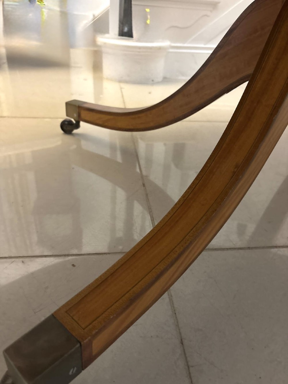 An antique Regency style oval mahogany tilt-top dining table featuring a figured timber top with satinwood crossbanding mounted on a pedestal base with brass castors. View II