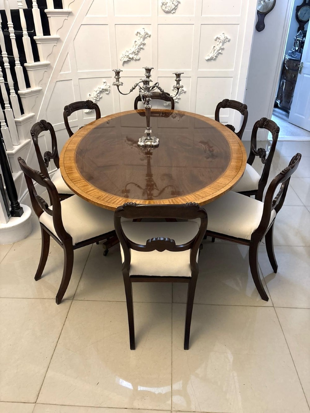 An antique Regency style oval mahogany tilt-top dining table featuring a figured timber top with satinwood crossbanding mounted on a pedestal base with brass castors. View VIII