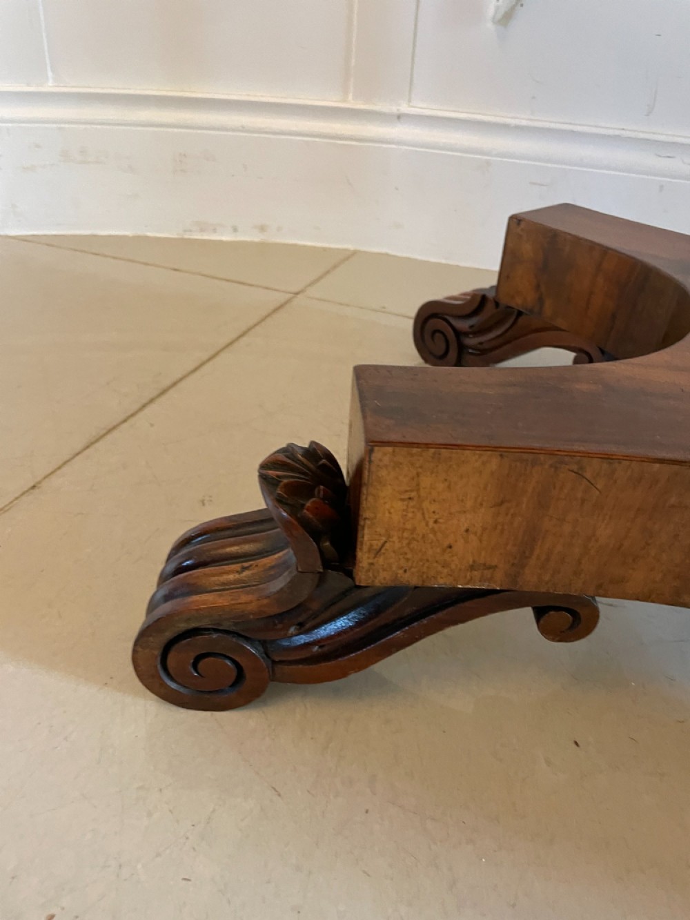 An antique Victorian rosewood fold-over card table featuring a carved frieze, a fluted pedestal column, and a quadform base with scroll feet. View V
