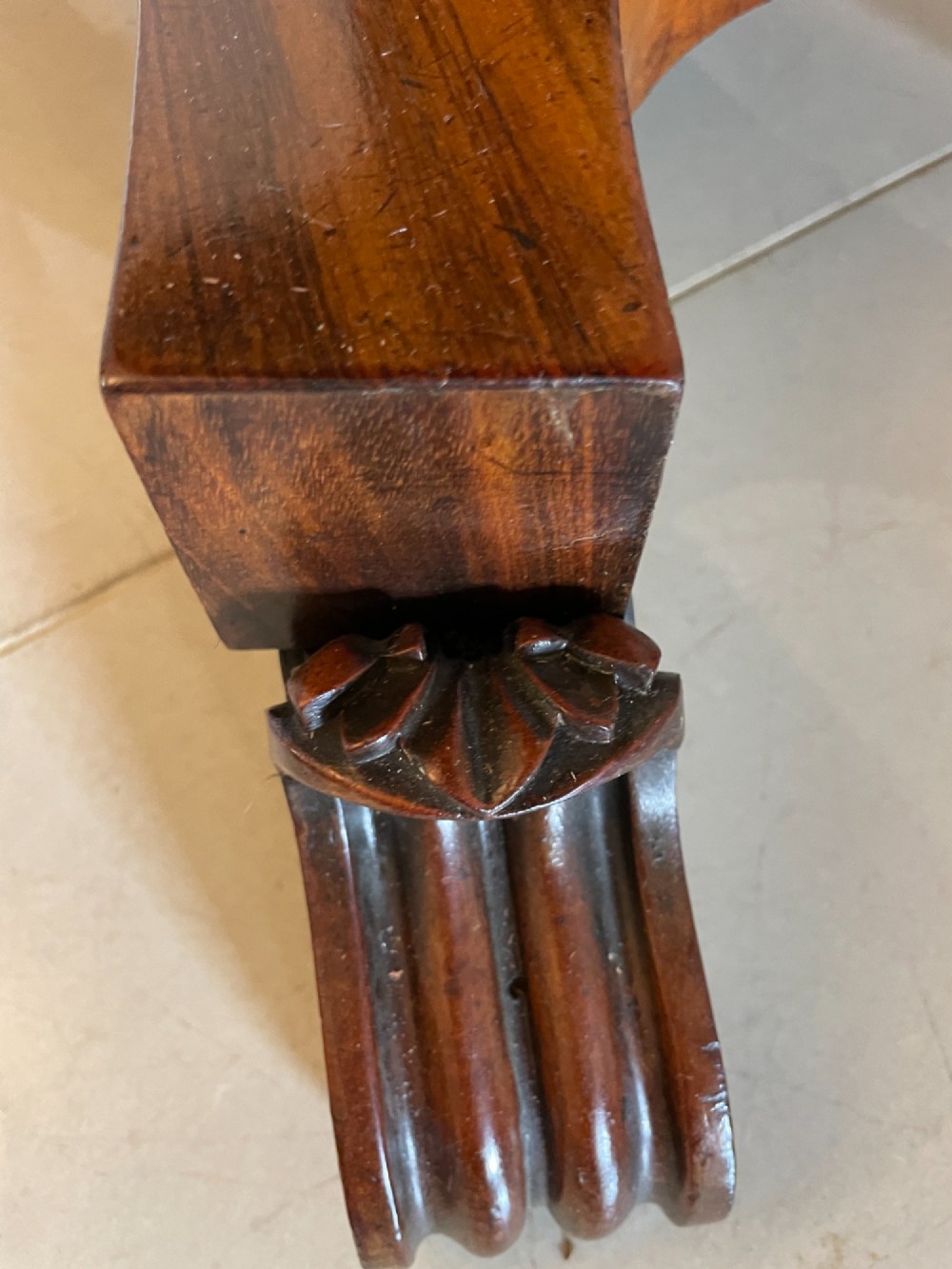 An antique Victorian rosewood fold-over card table featuring a carved frieze, a fluted pedestal column, and a quadform base with scroll feet. View VIII