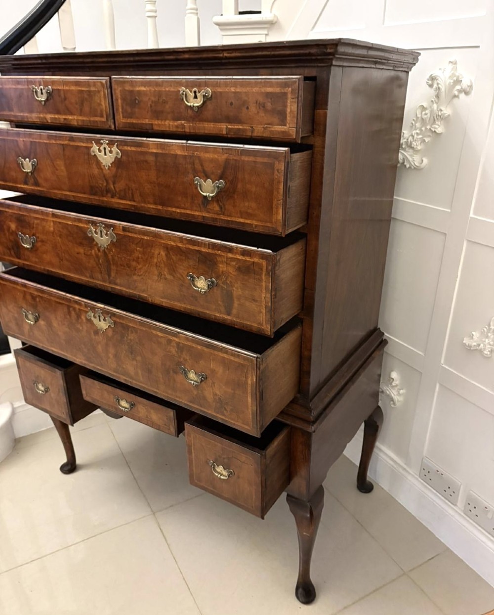 An early eighteenth-century George I walnut chest on stand featuring crossbanded drawers, brass drop handles, and cabriole legs with pad feet. View IV