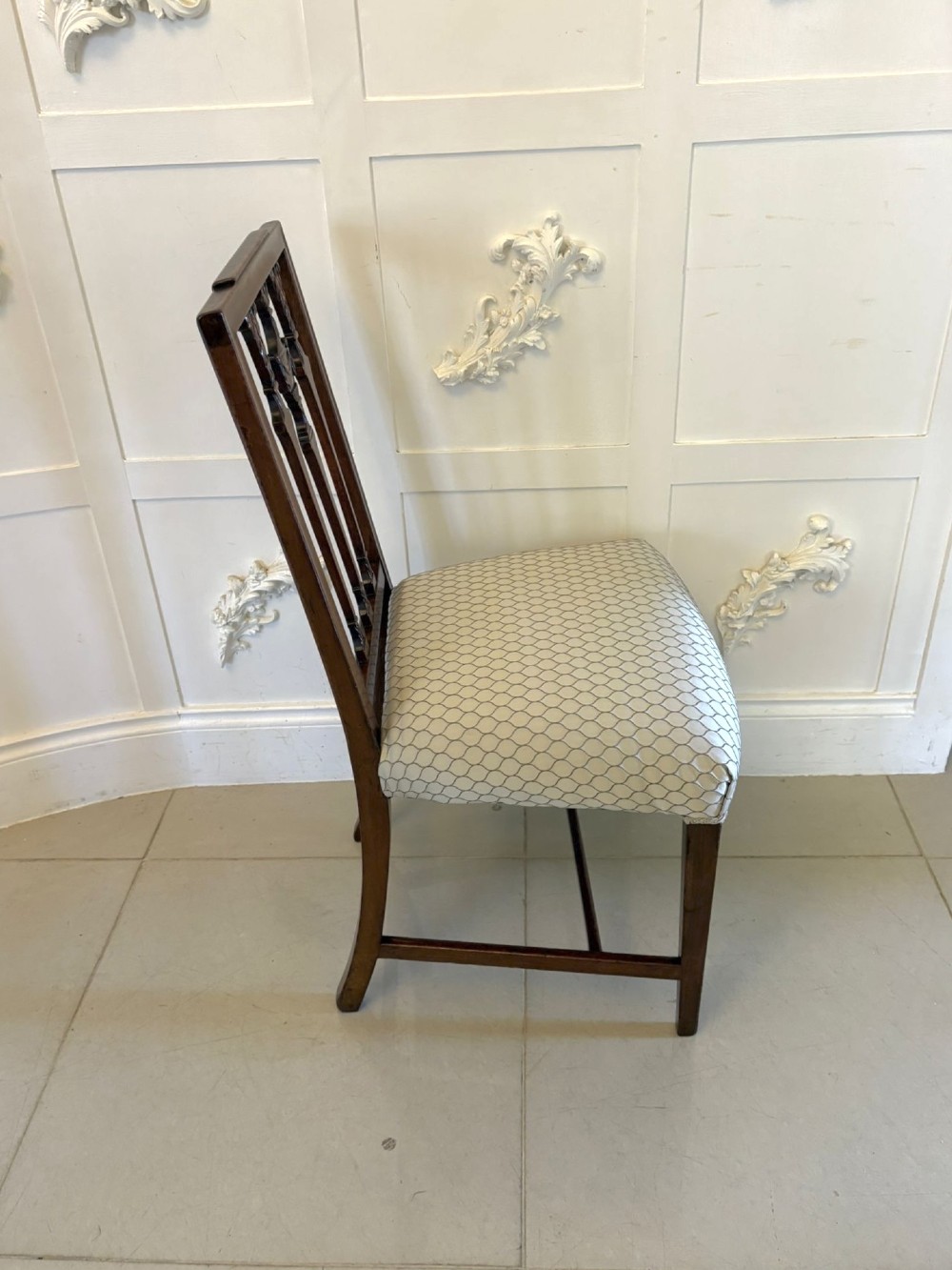 A set of eight dark mahogany Victorian dining chairs with carved backs and light geometric patterned upholstered seats, including two carvers with armrests. View V