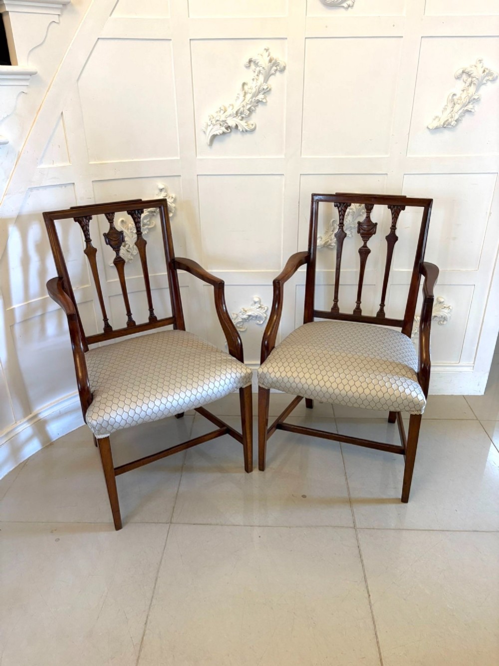A set of eight dark mahogany Victorian dining chairs with carved backs and light geometric patterned upholstered seats, including two carvers with armrests. View VI
