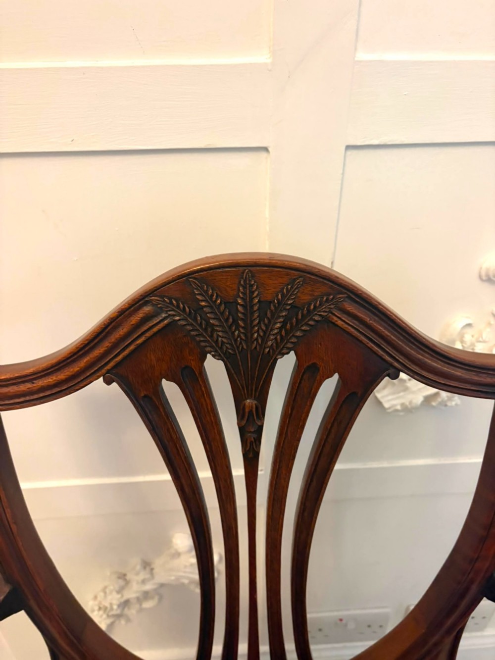 A set of twelve mahogany shield back dining chairs featuring carved backrest splats, square tapered legs, and blue patterned upholstered seats. View VIII