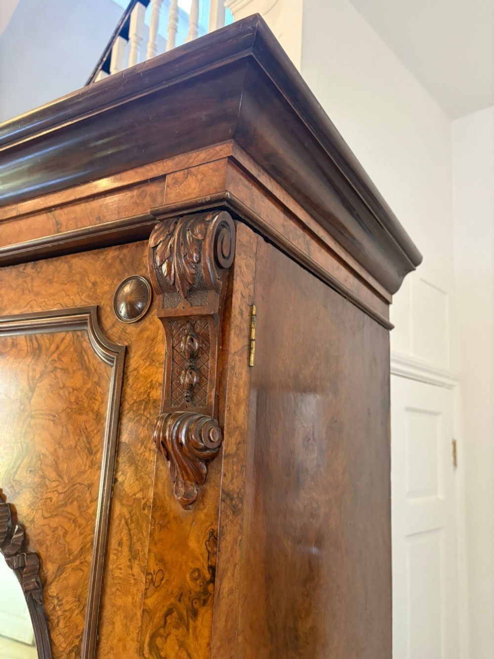 A large Victorian burr walnut three-door wardrobe with a central arched mirrored door, oval mirrors set into side panels, and carved pediment details. View IV