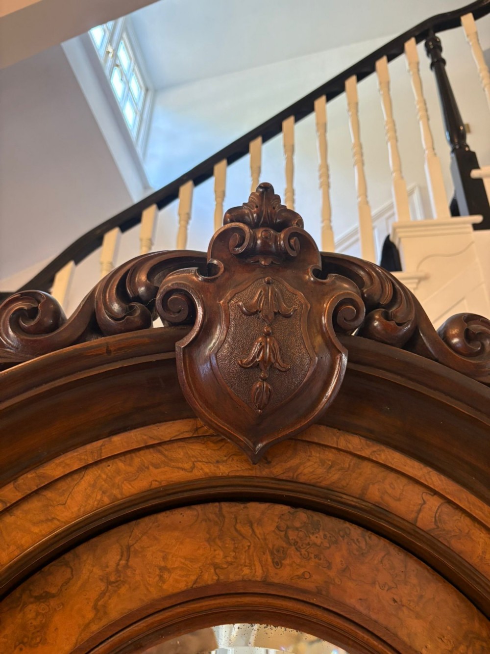 A large Victorian burr walnut three-door wardrobe with a central arched mirrored door, oval mirrors set into side panels, and carved pediment details. View X