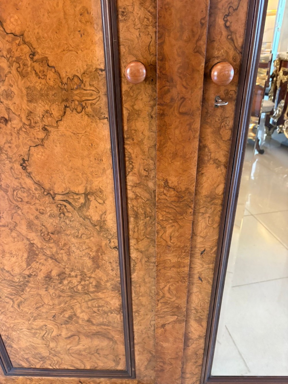 A large Victorian burr walnut three-door wardrobe with a central arched mirrored door, oval mirrors set into side panels, and carved pediment details. View XI