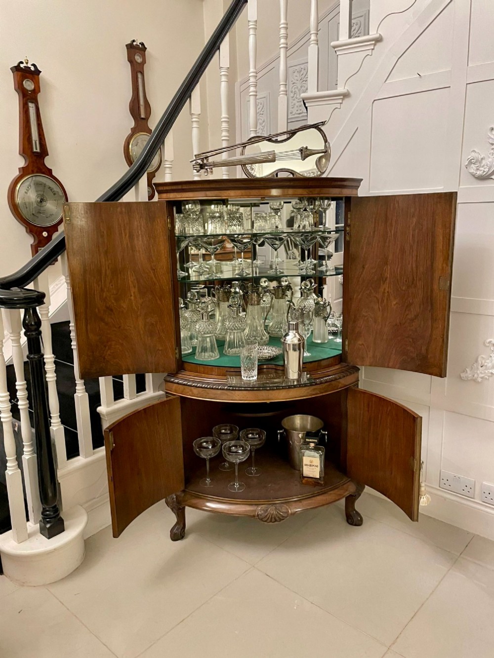 An antique burr walnut bow-fronted cocktail cabinet featuring two upper doors, two lower doors, carved cabriole legs, and brass keyhole escutcheons. View III