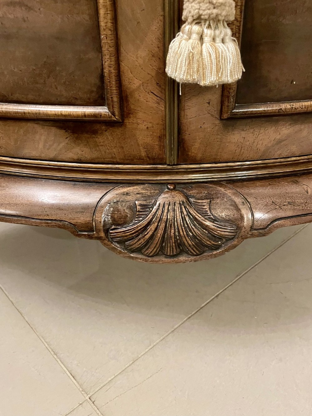 An antique burr walnut bow-fronted cocktail cabinet featuring two upper doors, two lower doors, carved cabriole legs, and brass keyhole escutcheons. View V