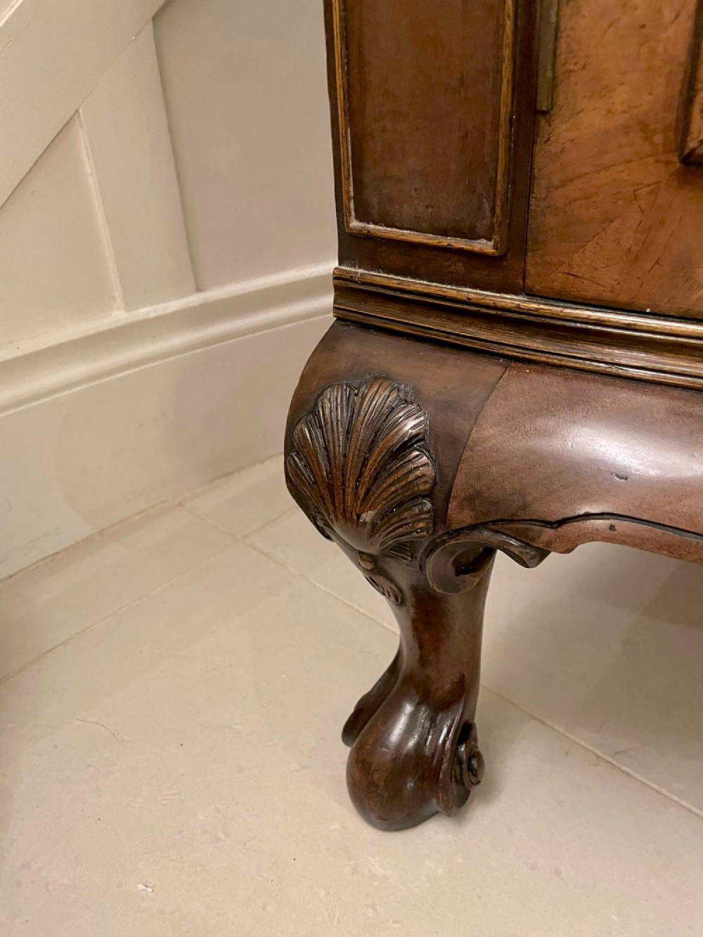 An antique burr walnut bow-fronted cocktail cabinet featuring two upper doors, two lower doors, carved cabriole legs, and brass keyhole escutcheons. View XIV
