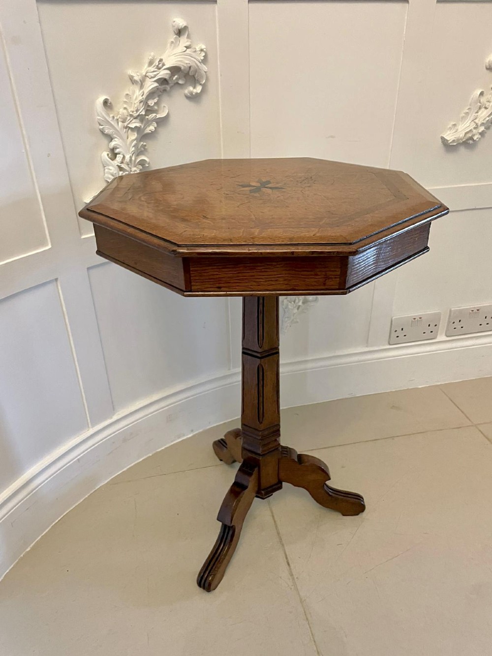 A Victorian octagonal oak lamp table featuring a central star marquetry inlay, a faceted pedestal column, and three carved tripod legs. View IX