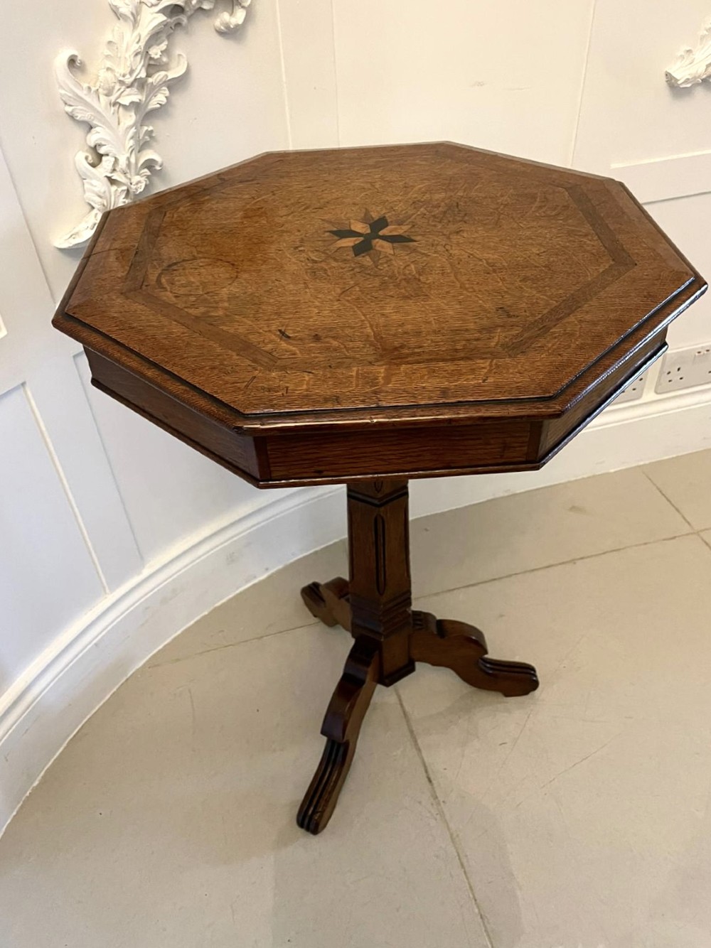 A Victorian octagonal oak lamp table featuring a central star marquetry inlay, a faceted pedestal column, and three carved tripod legs. View X