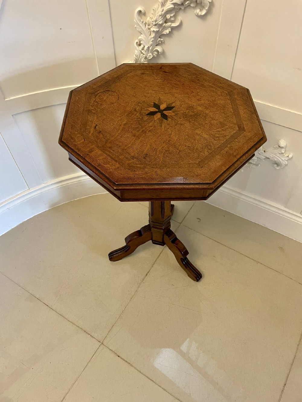 A Victorian octagonal oak lamp table featuring a central star marquetry inlay, a faceted pedestal column, and three carved tripod legs. View XII