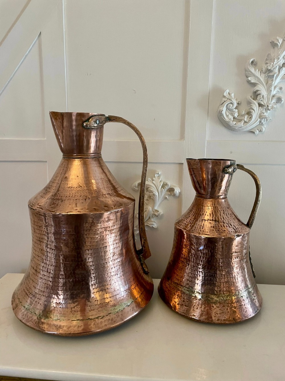 A large George III hand-hammered copper water jug featuring a flared base, narrow neck, and riveted strap handle. View III