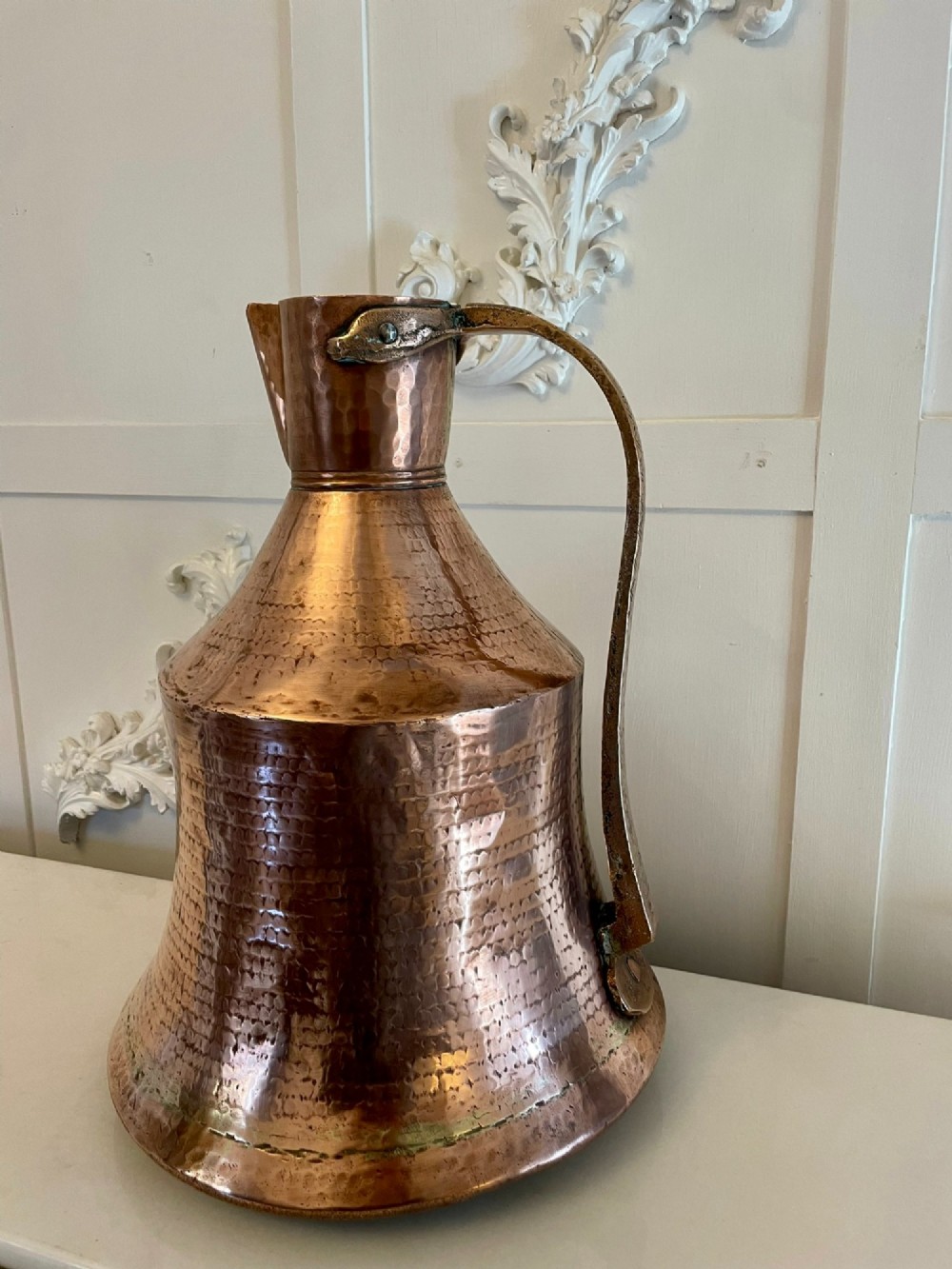 A large George III hand-hammered copper water jug featuring a flared base, narrow neck, and riveted strap handle. View IV