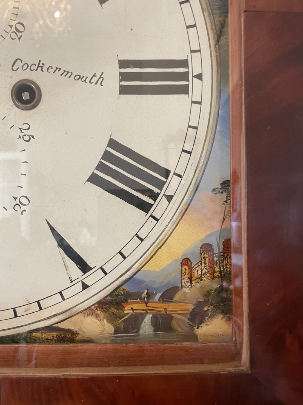 A George III flame mahogany longcase clock featuring a swan-neck pediment, turned hood columns, a painted arch dial, and a gothic-arched trunk door. View IX
