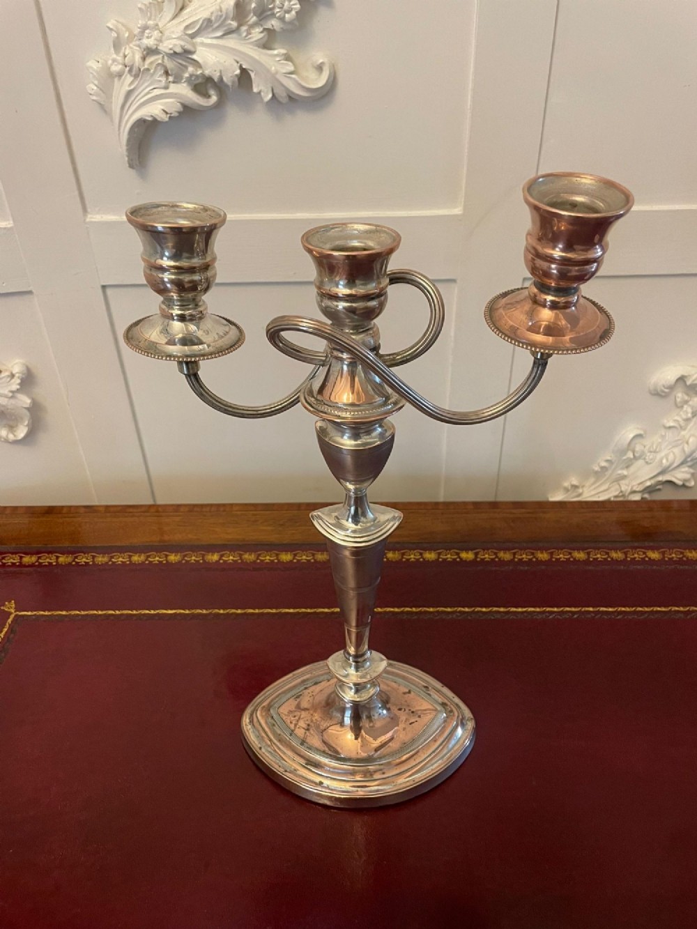 A pair of antique silver-plated three-light candelabras with curved branch arms, tapered baluster stems, and moulded oval bases showing subtle copper undertones. View III