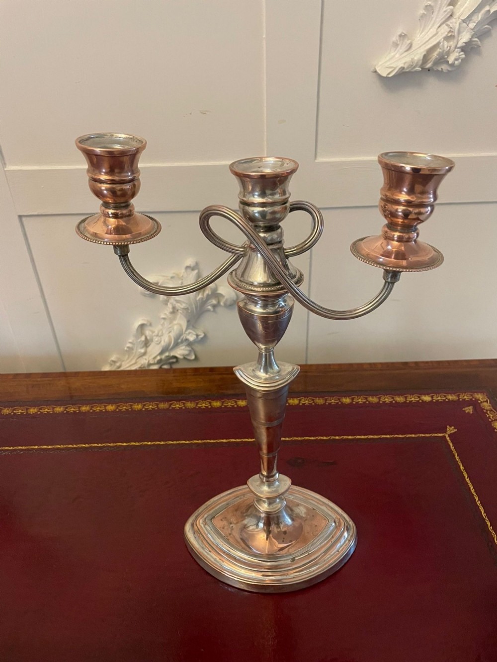 A pair of antique silver-plated three-light candelabras with curved branch arms, tapered baluster stems, and moulded oval bases showing subtle copper undertones. View VII