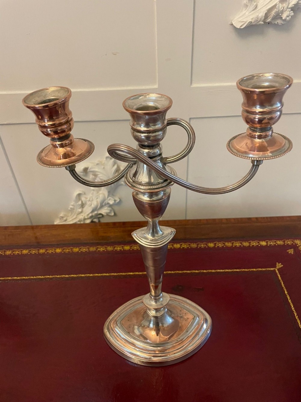 A pair of antique silver-plated three-light candelabras with curved branch arms, tapered baluster stems, and moulded oval bases showing subtle copper undertones. View VIII