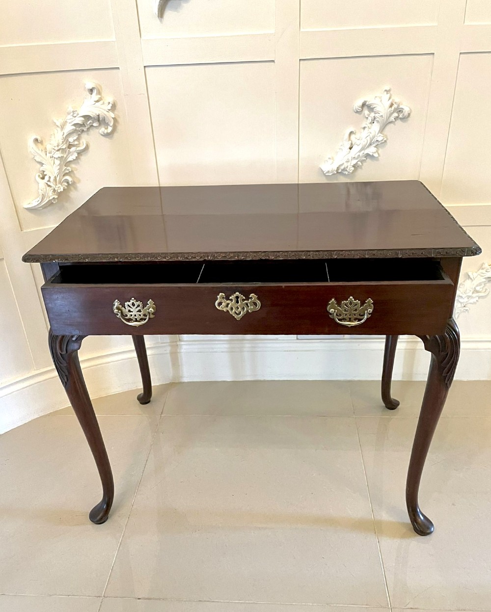 A George III mahogany side table featuring a rectangular top with carved moulding, a long drawer with brass handles, and cabriole legs. View III