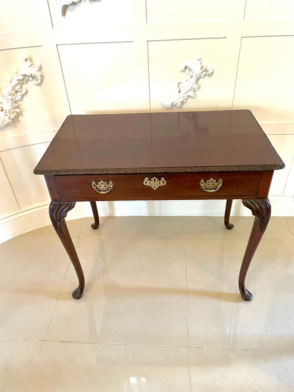 A George III mahogany side table featuring a rectangular top with carved moulding, a long drawer with brass handles, and cabriole legs. View VI