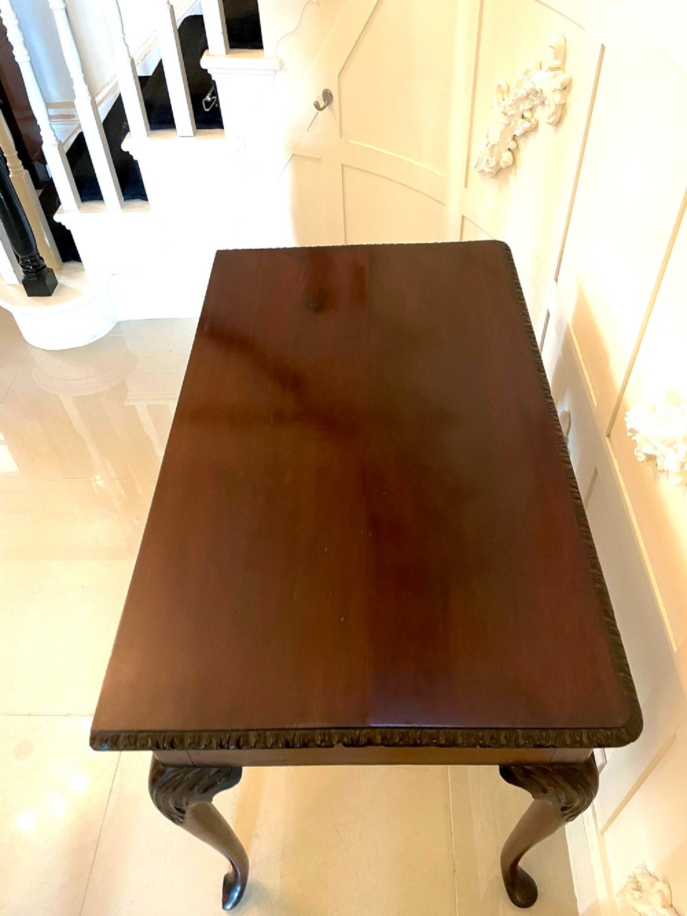 A George III mahogany side table featuring a rectangular top with carved moulding, a long drawer with brass handles, and cabriole legs. View X