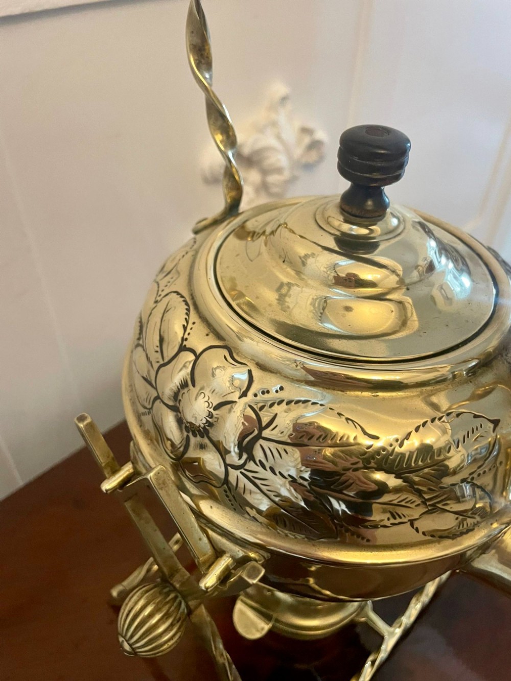 An antique Victorian brass spirit kettle featuring floral engravings, an ebonised wooden handle, and a matching brass stand with a spirit burner. View IV