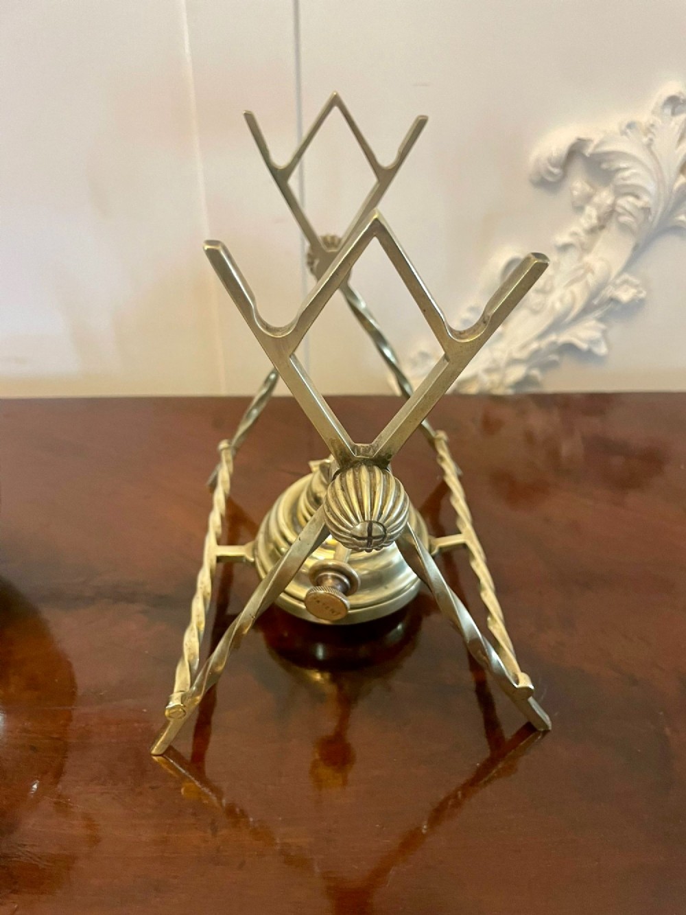 An antique Victorian brass spirit kettle featuring floral engravings, an ebonised wooden handle, and a matching brass stand with a spirit burner. View VI