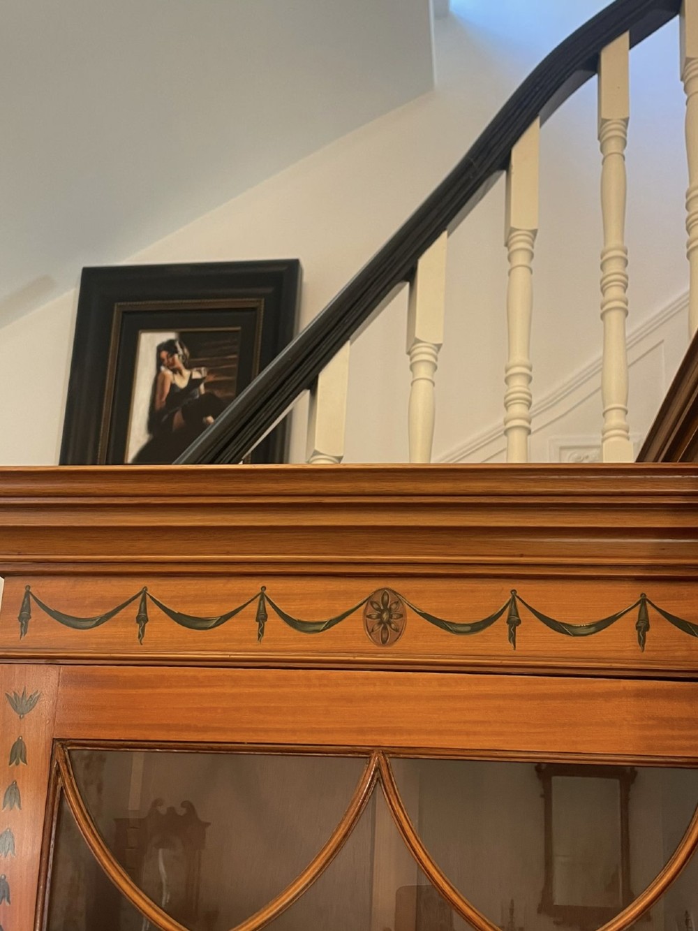A large satinwood breakfront bookcase featuring hand-painted floral cartouches, upper glazed display doors, and lower cupboard panels. View XIII