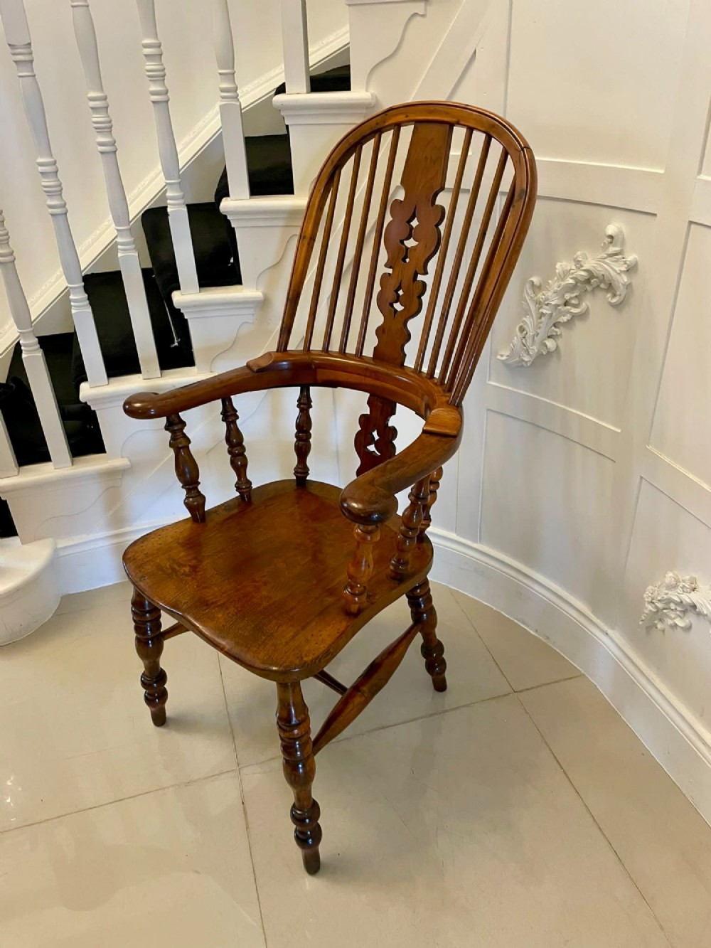 An antique Victorian yew wood Windsor armchair featuring a hoop back, spindle backrest with a central pierced splat, broad arms, and turned legs. View III