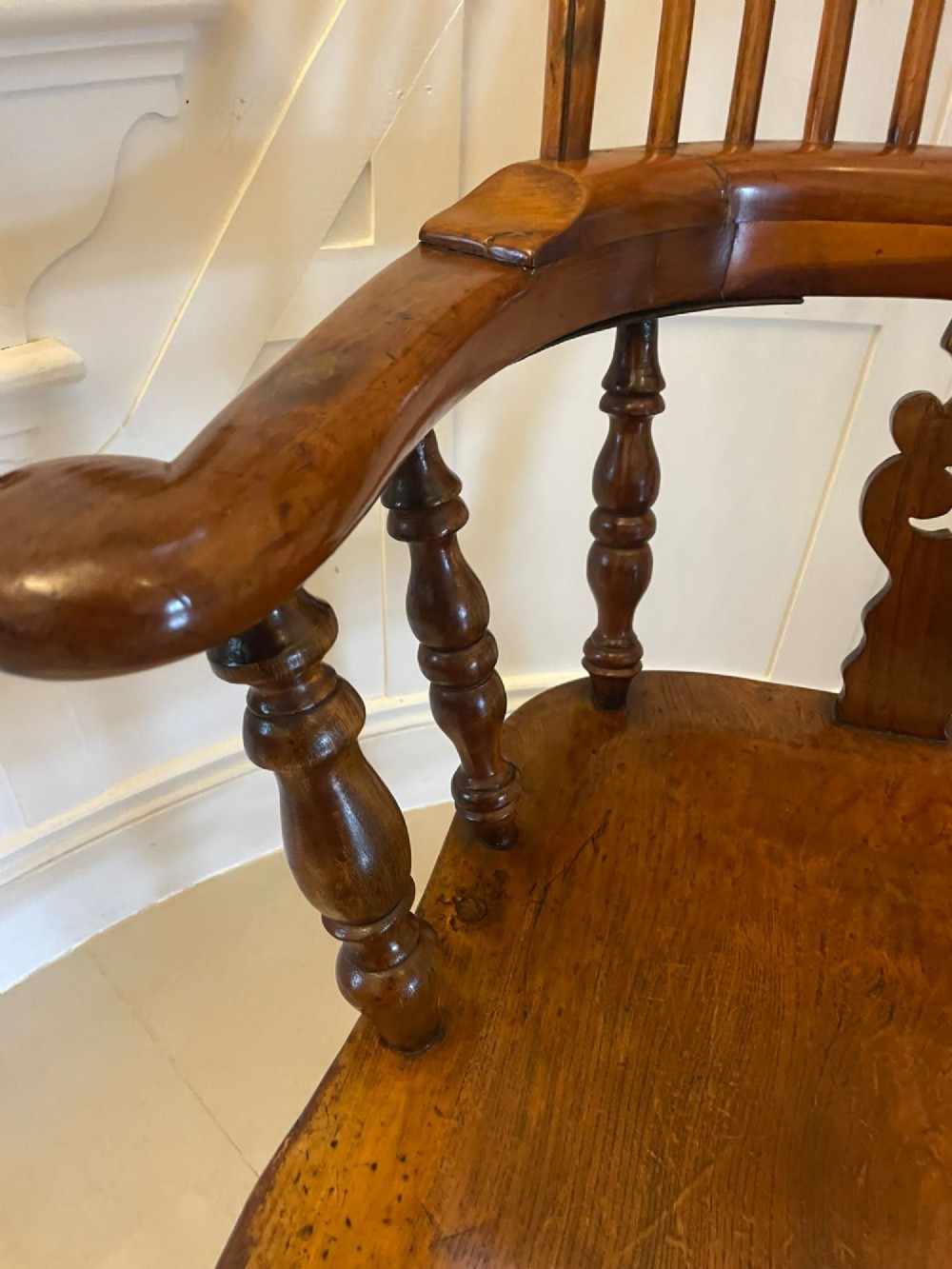 An antique Victorian yew wood Windsor armchair featuring a hoop back, spindle backrest with a central pierced splat, broad arms, and turned legs. View V