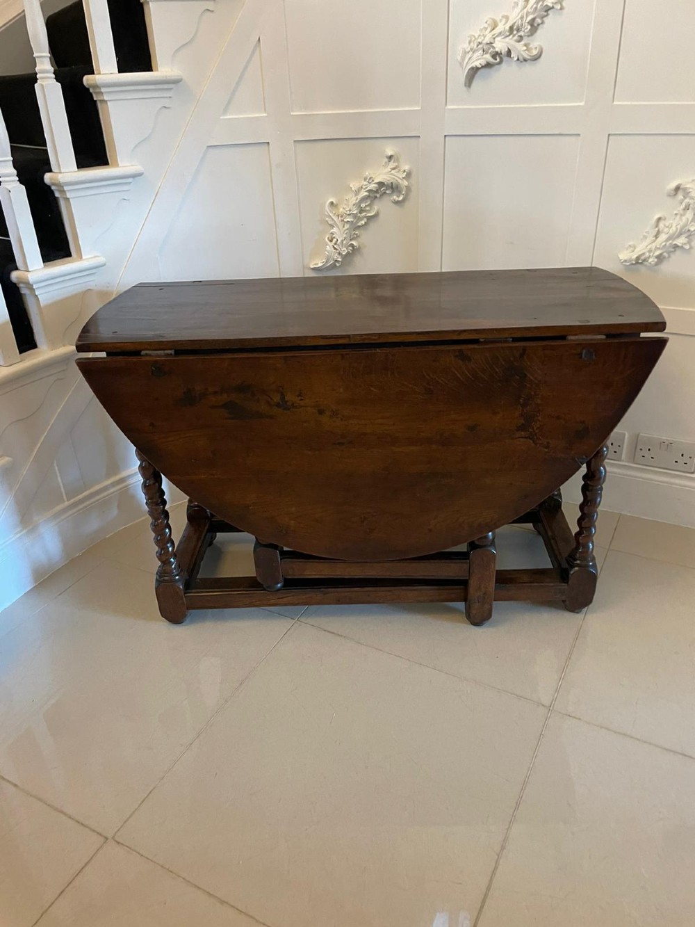 A dark oak seventeenth-century gateleg dining table with folded drop leaves, barley twist legs, and sturdy base stretchers. View III