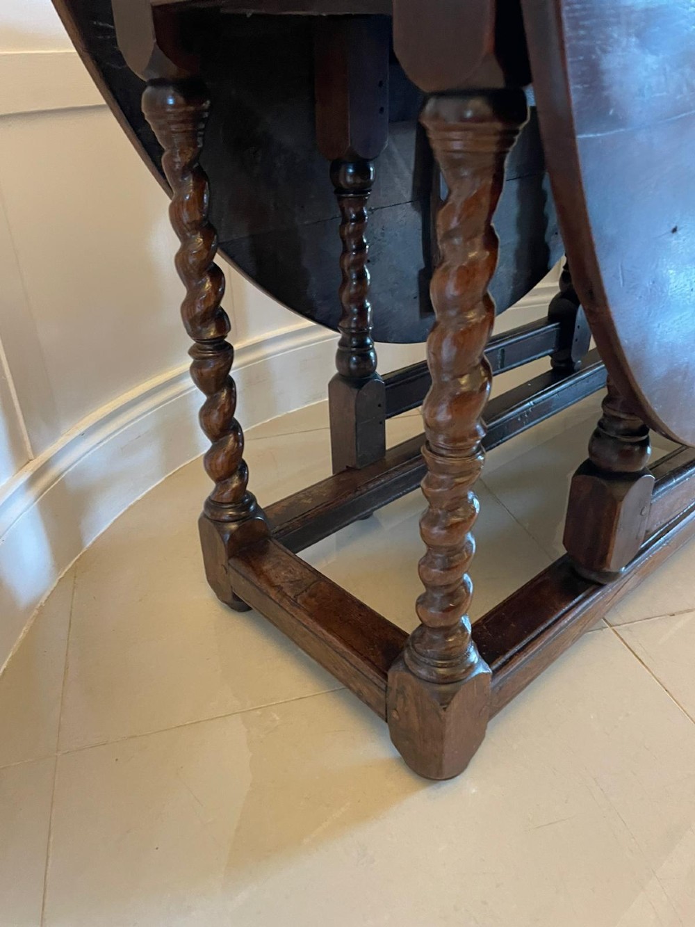 A dark oak seventeenth-century gateleg dining table with folded drop leaves, barley twist legs, and sturdy base stretchers. View IV
