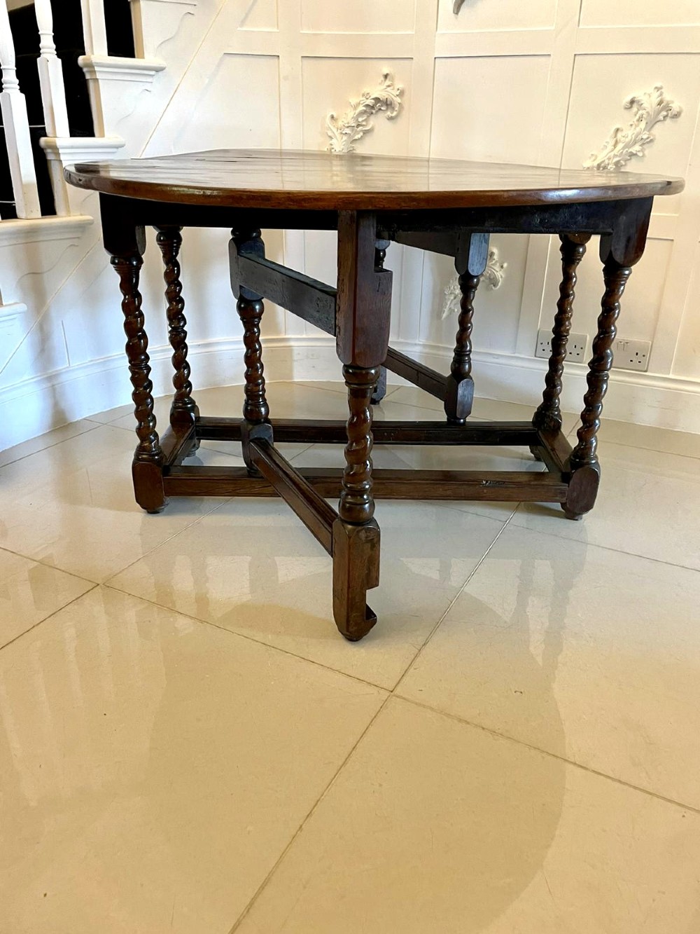 A dark oak seventeenth-century gateleg dining table with folded drop leaves, barley twist legs, and sturdy base stretchers. View VII