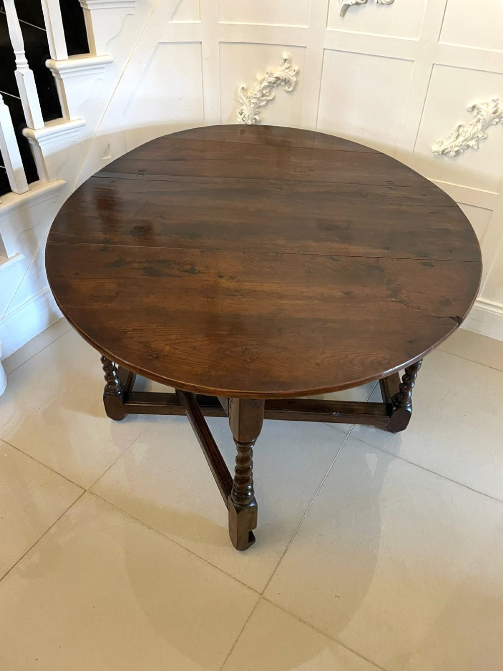 A dark oak seventeenth-century gateleg dining table with folded drop leaves, barley twist legs, and sturdy base stretchers. View VIII