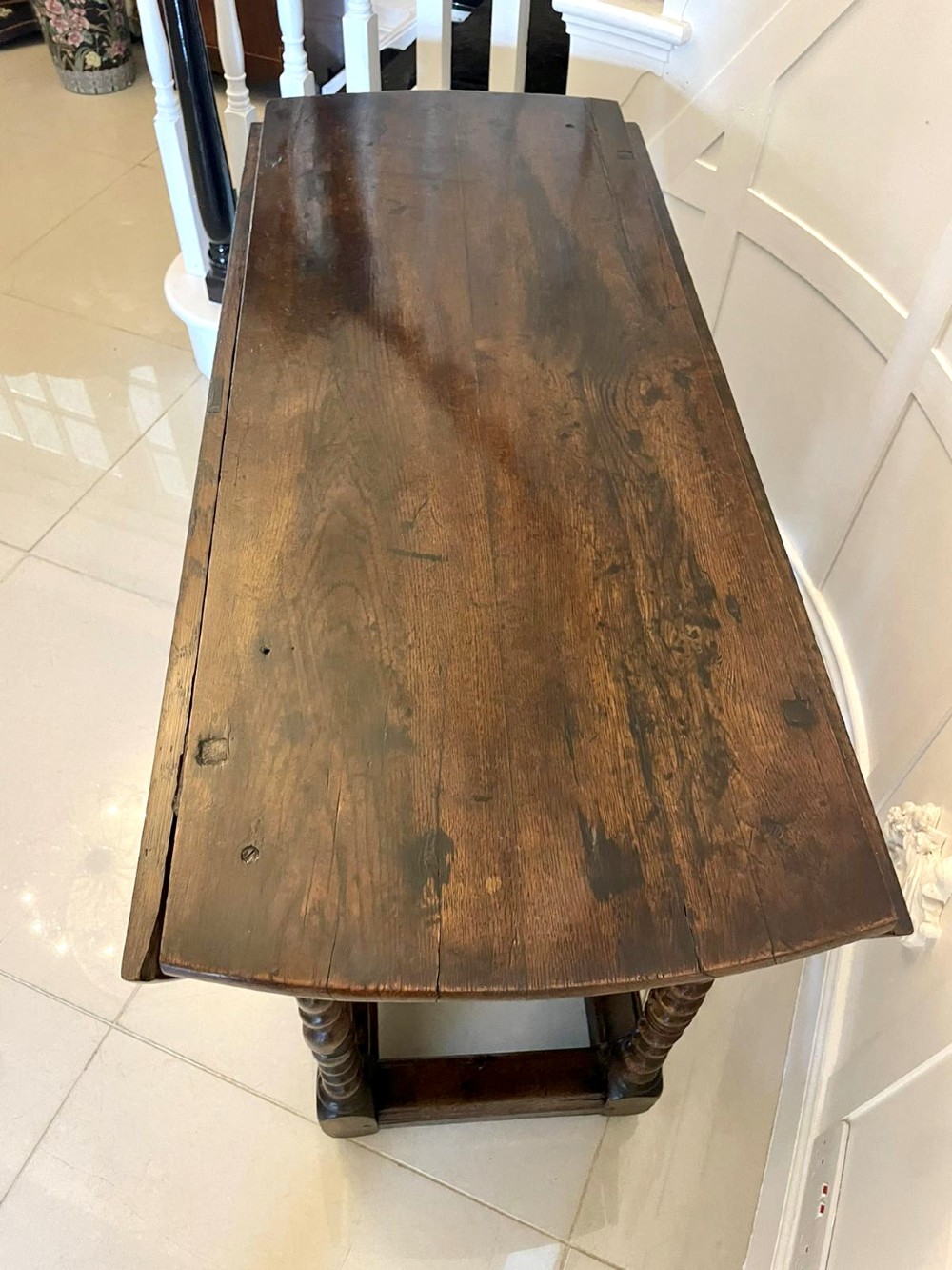 A dark oak seventeenth-century gateleg dining table with folded drop leaves, barley twist legs, and sturdy base stretchers. View IX