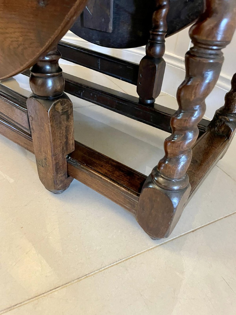 A dark oak seventeenth-century gateleg dining table with folded drop leaves, barley twist legs, and sturdy base stretchers. View XI