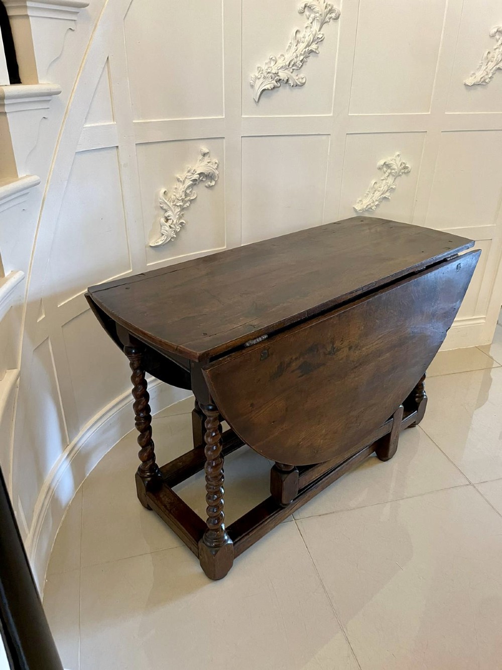A dark oak seventeenth-century gateleg dining table with folded drop leaves, barley twist legs, and sturdy base stretchers. View XIII