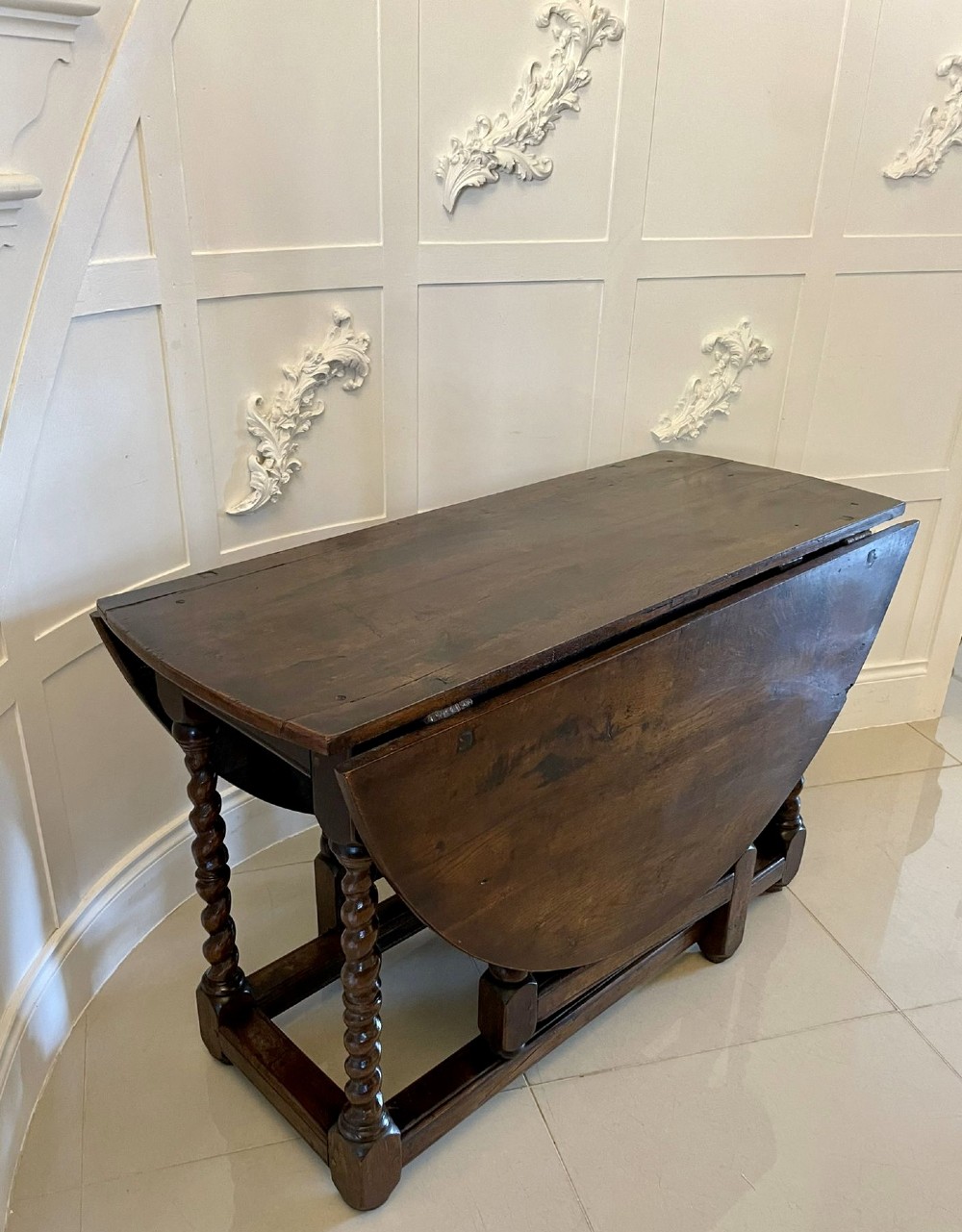 A dark oak seventeenth-century gateleg dining table with folded drop leaves, barley twist legs, and sturdy base stretchers. View XIV