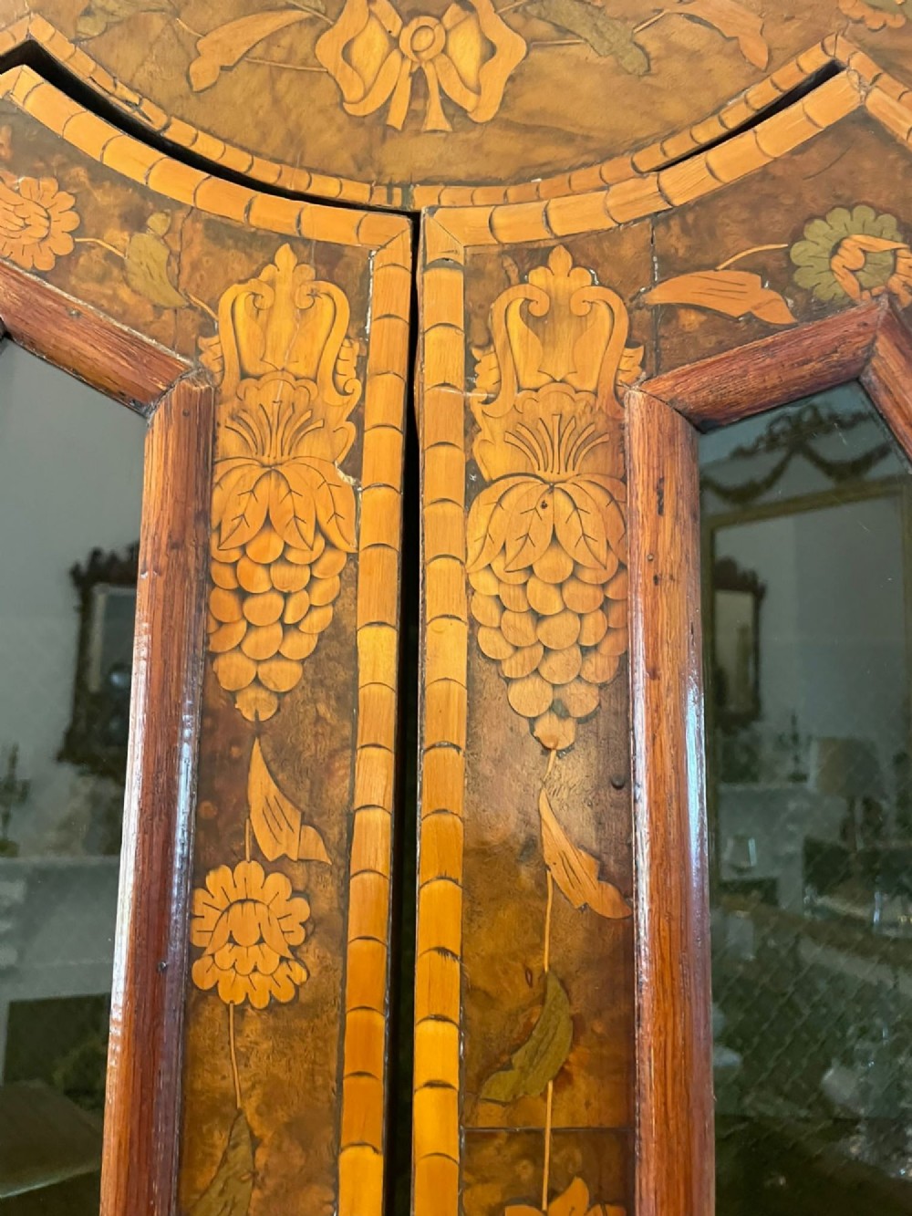 An antique Dutch burr walnut display cabinet featuring elaborate floral marquetry inlay, glazed upper doors, a serpentine three-drawer base, and carved claw feet. View V