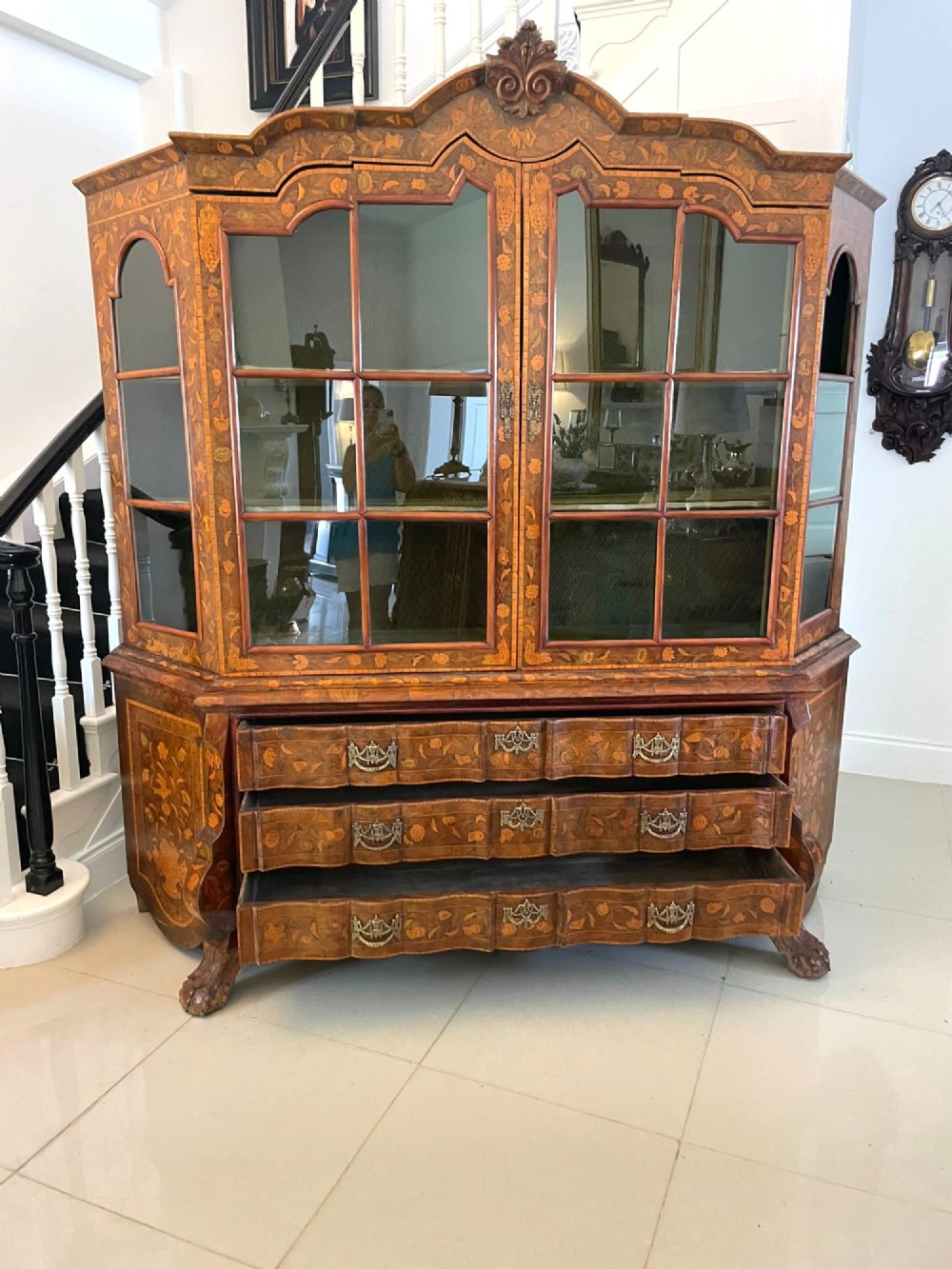 An antique Dutch burr walnut display cabinet featuring elaborate floral marquetry inlay, glazed upper doors, a serpentine three-drawer base, and carved claw feet. View IX