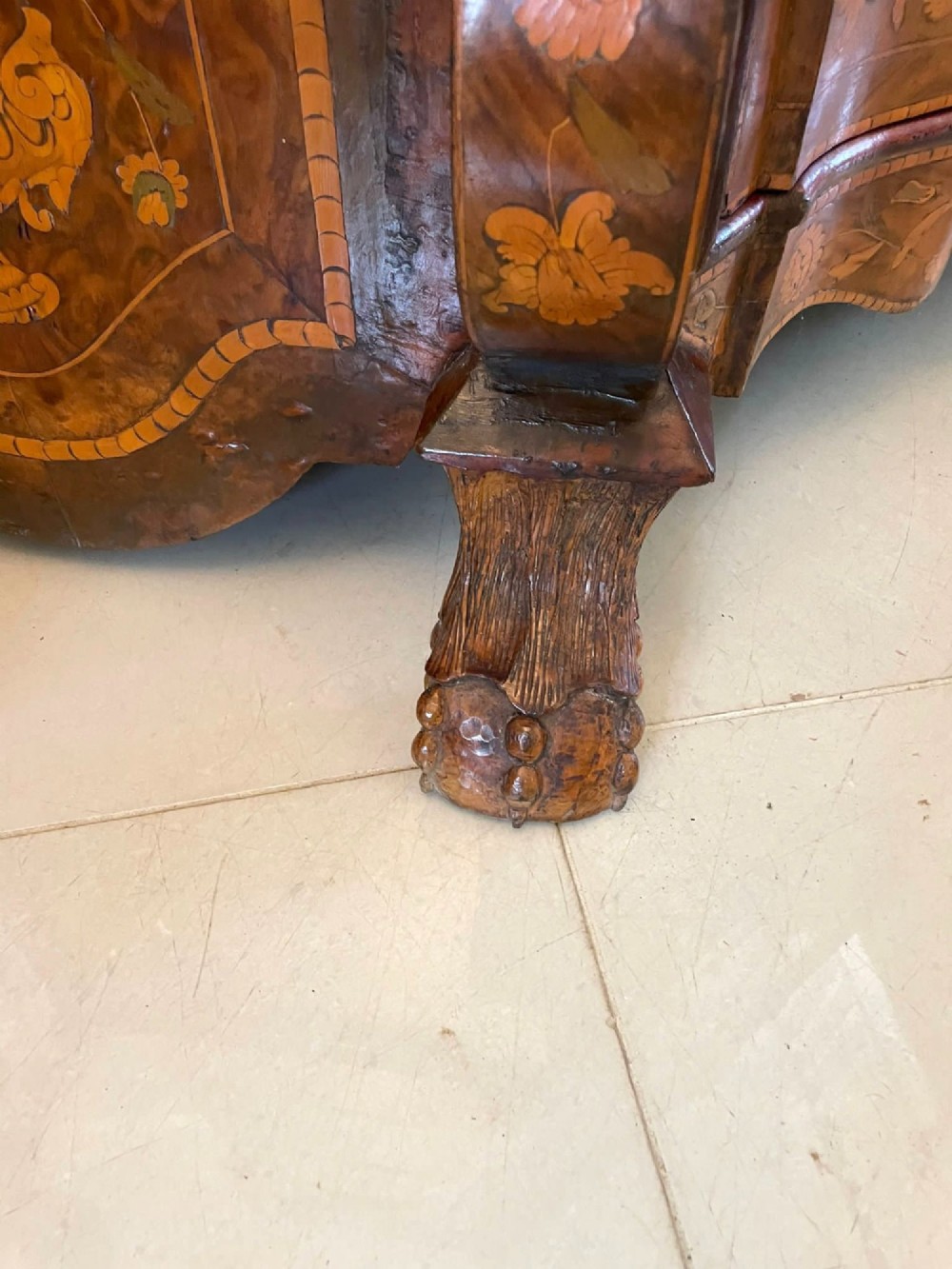 An antique Dutch burr walnut display cabinet featuring elaborate floral marquetry inlay, glazed upper doors, a serpentine three-drawer base, and carved claw feet. View XII